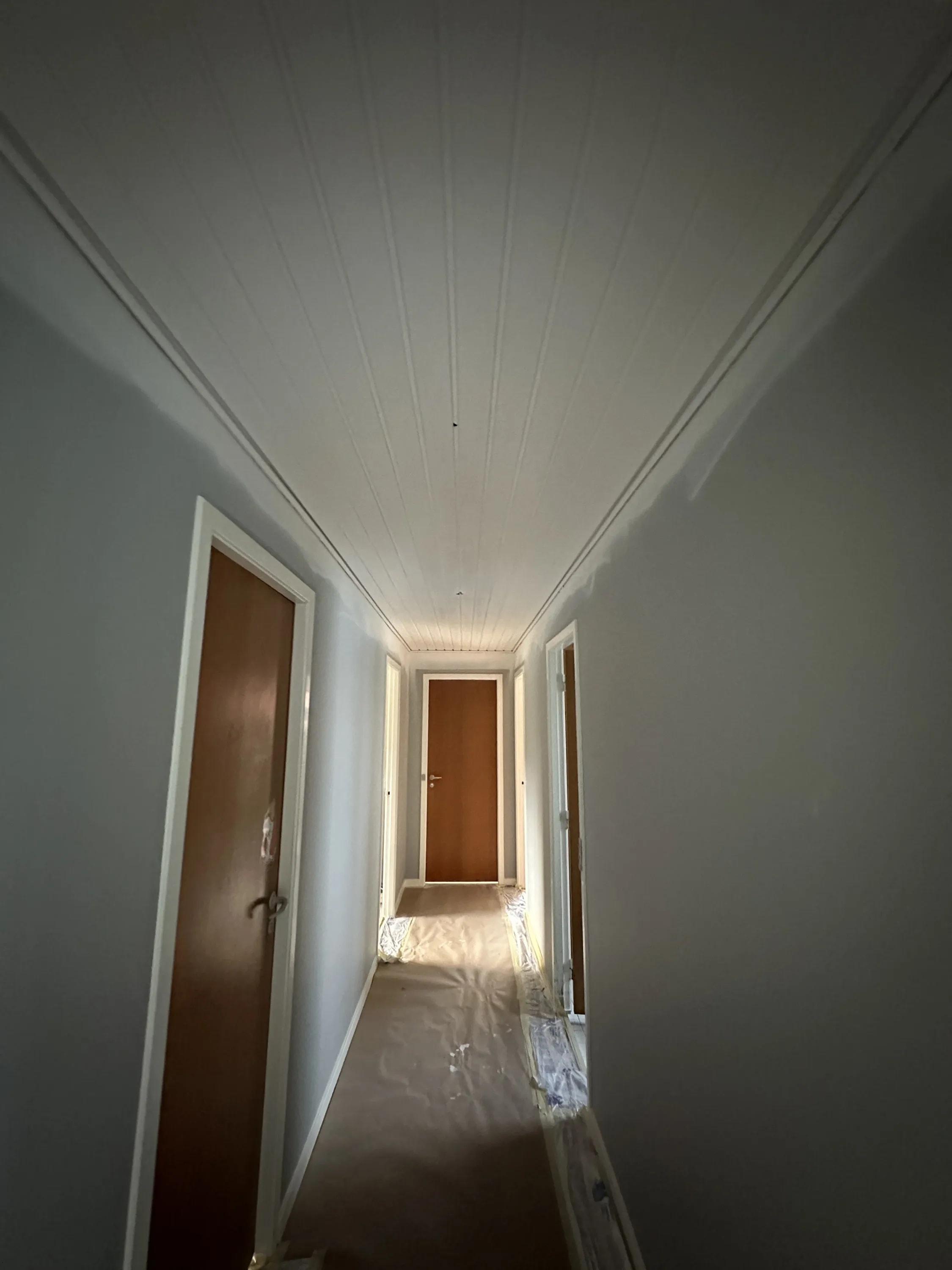Rum med hvidmalet loft og panel-væg efter sprøjtemaling, Risskov