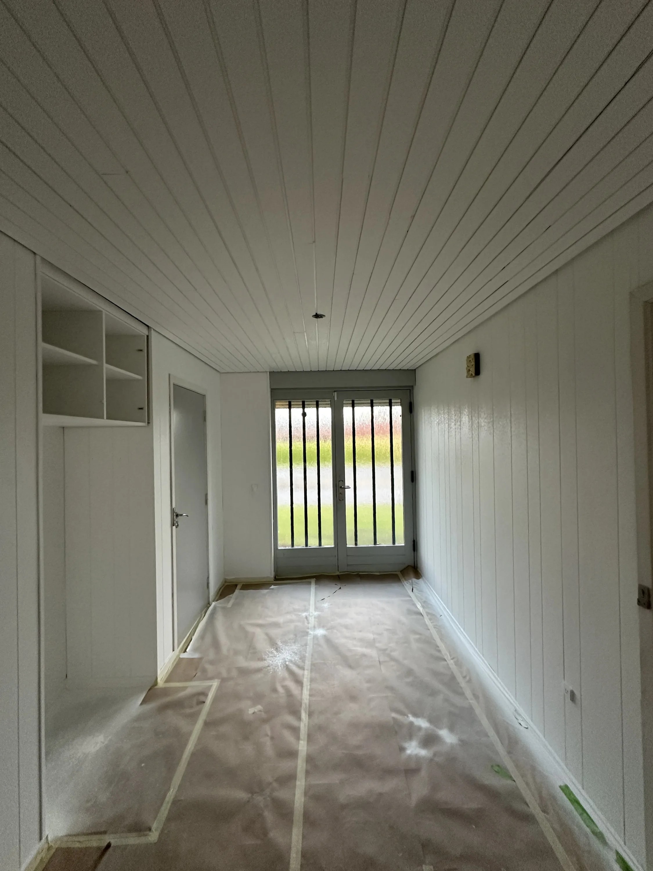 Værelse med hvidt loft, panel-væg og vindue efter loftmaling, Aarhus Risskov