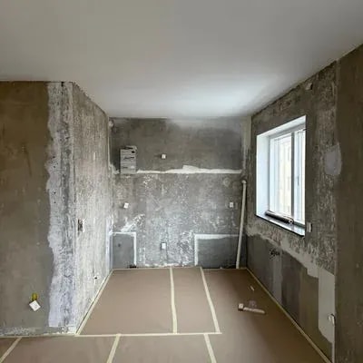 Rum med afrenset væg og afdækket gulv klar til spartling, malerrenovering Skejbytoften