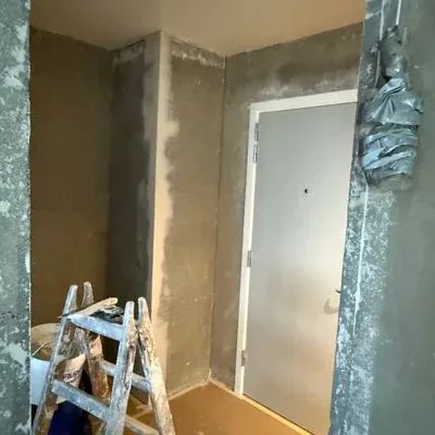 Spartlet rum med hvid dør og stige under malerarbejde, renovering Skejbytoften