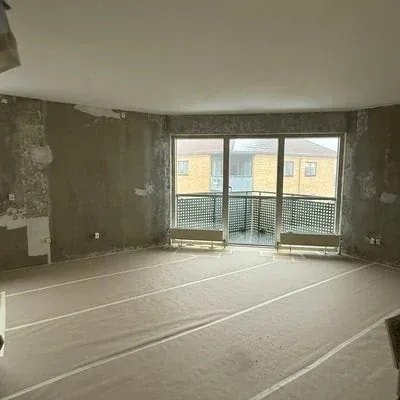 Stue med afrenset væg og afdækket gulv før spartling og maling, Aarhus Skejby