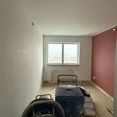 Værelse med koralfarvet væg og malerudstyr under renovering, Skejbytoften
